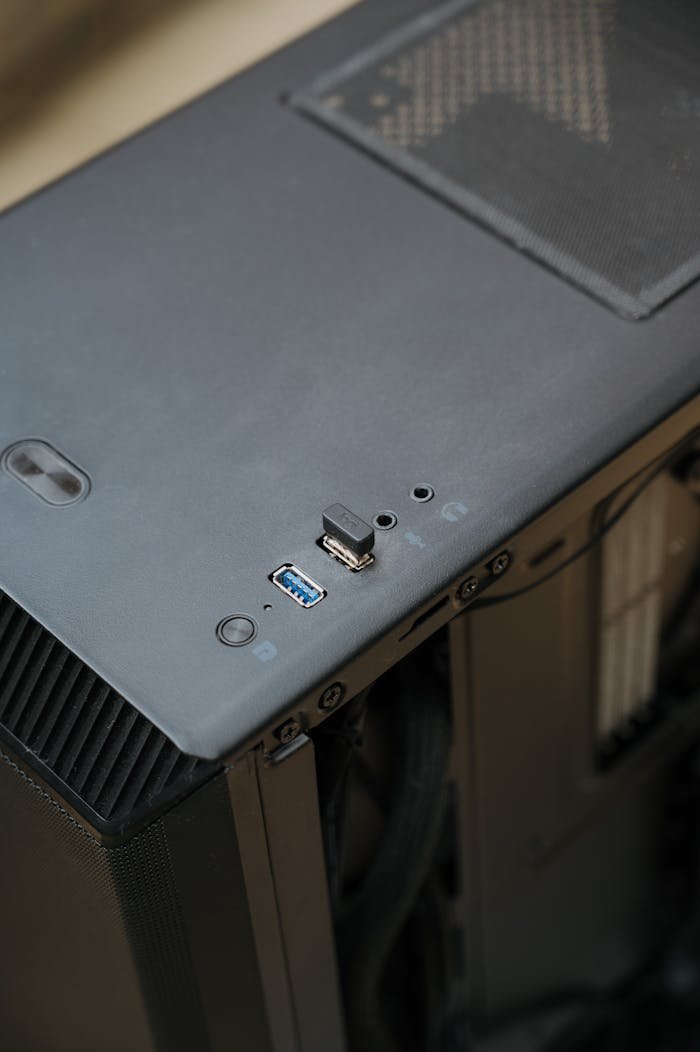 Detailed view of a computer tower's USB ports and ventilated top panel, emphasizing technology maintenance.